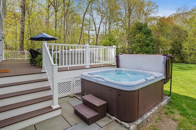 deck featuring a lawn, a hot tub, and a patio
