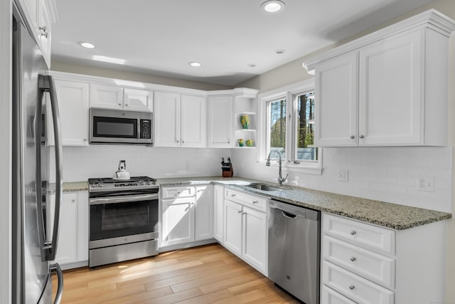 kitchen with a sink, white cabinets, and stainless steel appliances