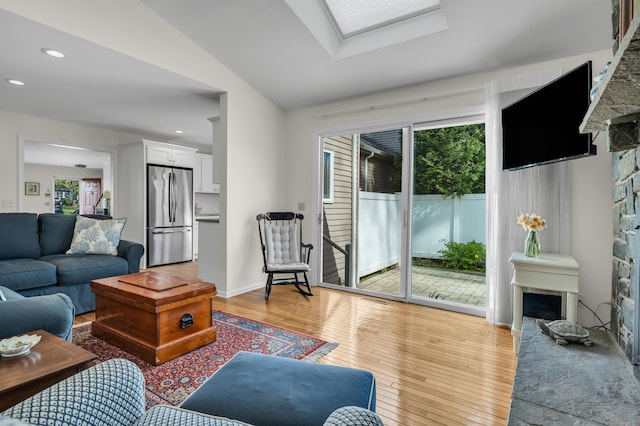 living room with recessed lighting, a healthy amount of sunlight, light wood finished floors, and a fireplace