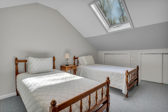 bedroom featuring carpet flooring, baseboards, two closets, and vaulted ceiling with skylight