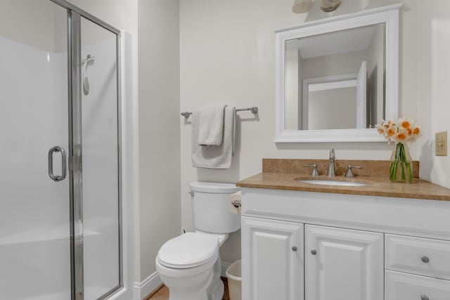 bathroom with vanity, a stall shower, and toilet