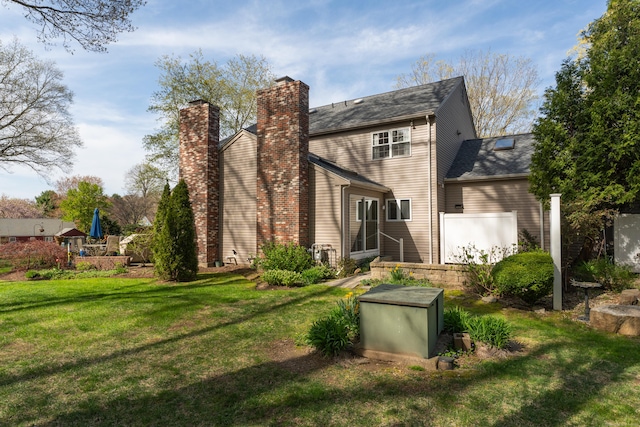 back of house with a yard and a chimney