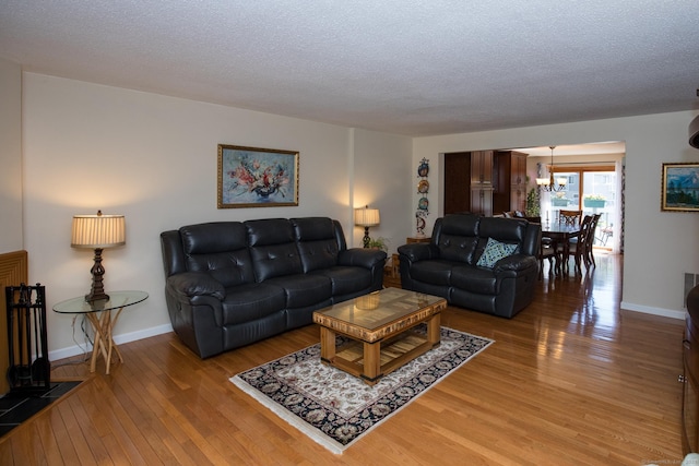 17 Ives Hill Ct Unit 17, Cheshire, CT 06410 - living area with a chandelier, light wood-style floors, a textured ceiling, and baseboards