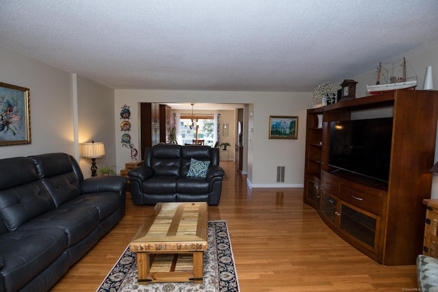 17 Ives Hill Ct Unit 17, Cheshire, CT 06410 - living area featuring a chandelier, light wood-style floors, a textured ceiling, and baseboards