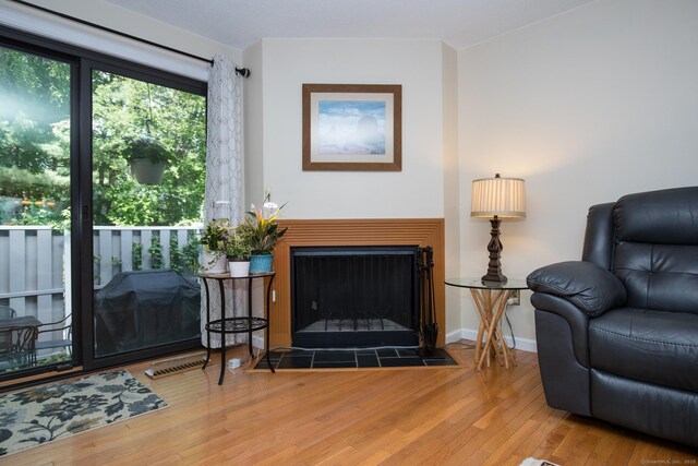 17 Ives Hill Ct Unit 17, Cheshire, CT 06410 - living area featuring hardwood / wood-style flooring, a fireplace with flush hearth, and baseboards