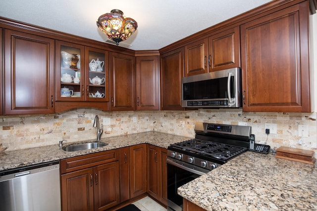 17 Ives Hill Ct Unit 17, Cheshire, CT 06410 - kitchen featuring stainless steel appliances, a sink, light stone counters, backsplash, and glass insert cabinets