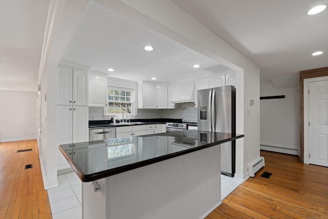 kitchen featuring a sink, white cabinetry, a baseboard heating unit, and dark countertops