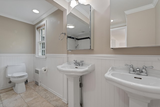 bathroom with wainscoting, a sink, toilet, radiator, and ornamental molding