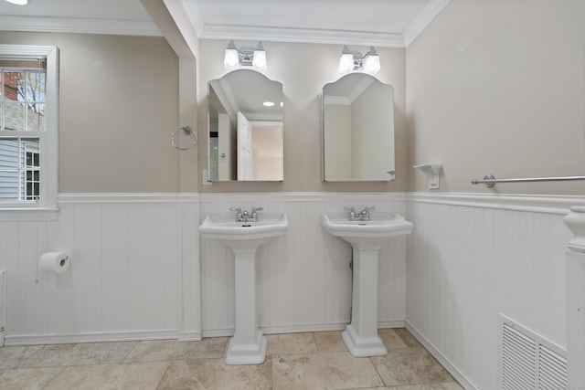 bathroom featuring visible vents, crown molding, and a wainscoted wall