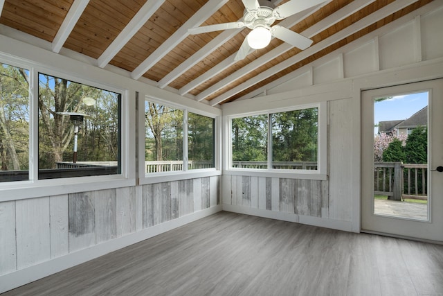 unfurnished sunroom featuring a ceiling fan, vaulted ceiling with beams, wood ceiling, and wood finished floors