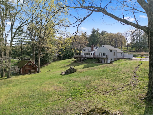 view of yard featuring a wooden deck and an outdoor structure
