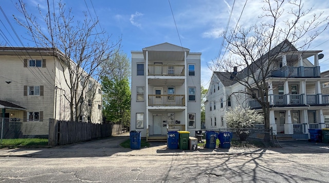 view of front of property with fence and a balcony