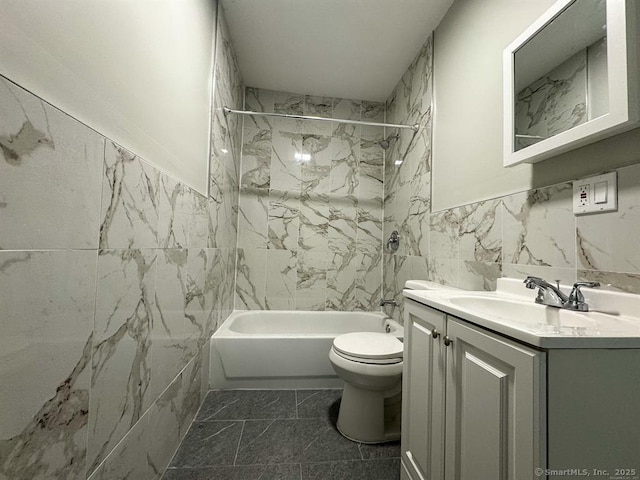 full bath featuring vanity, marble finish floor, toilet, bathing tub / shower combination, and tile walls