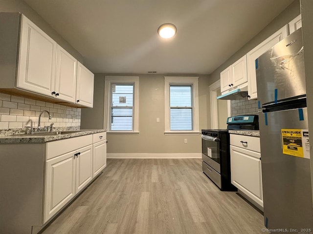 kitchen featuring decorative backsplash, appliances with stainless steel finishes, baseboards, white cabinets, and light wood finished floors