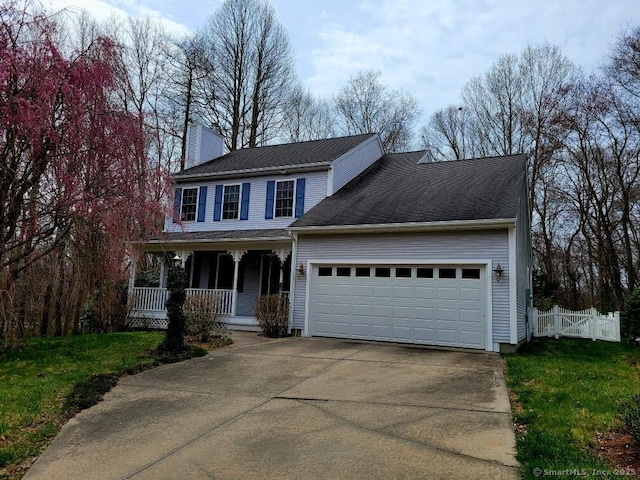 traditional home with fence, an attached garage, a chimney, concrete driveway, and covered porch