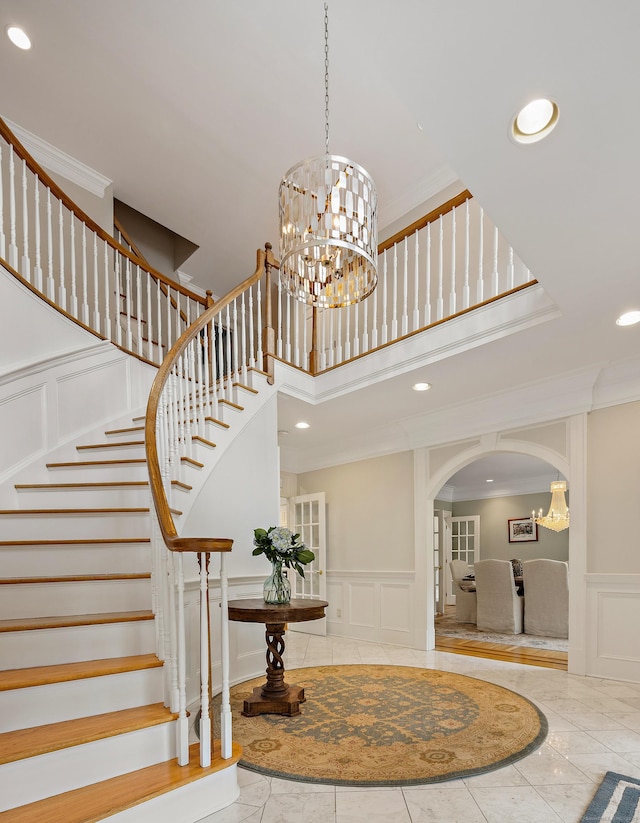 132 Belden Hill Rd, Wilton, CT 06897 - stairway with a decorative wall, crown molding, a chandelier, arched walkways, and recessed lighting