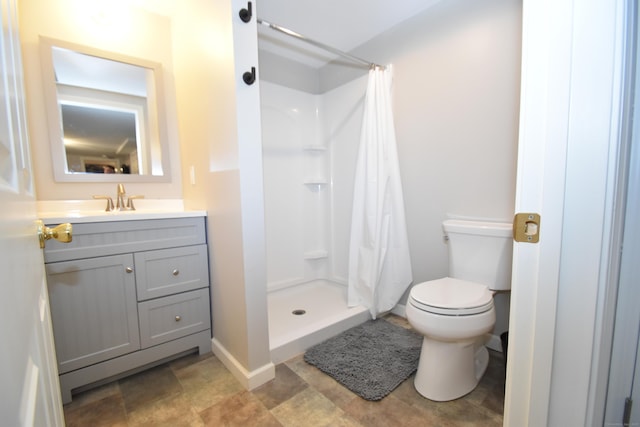 bathroom featuring vanity, baseboards, a shower stall, and toilet