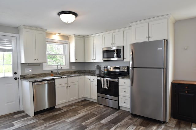 kitchen with dark wood-type flooring, a sink, white cabinetry, and stainless steel appliances