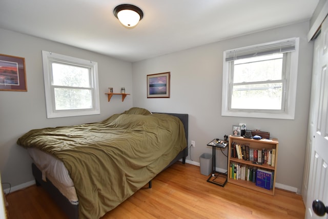 bedroom featuring baseboards, a closet, and wood finished floors