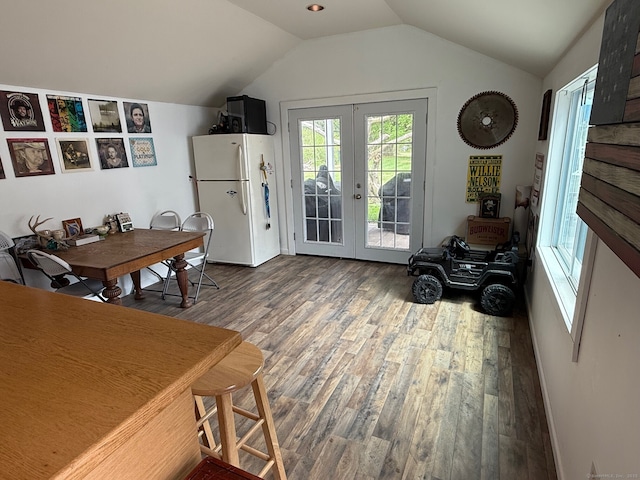 interior space with vaulted ceiling, french doors, and wood finished floors