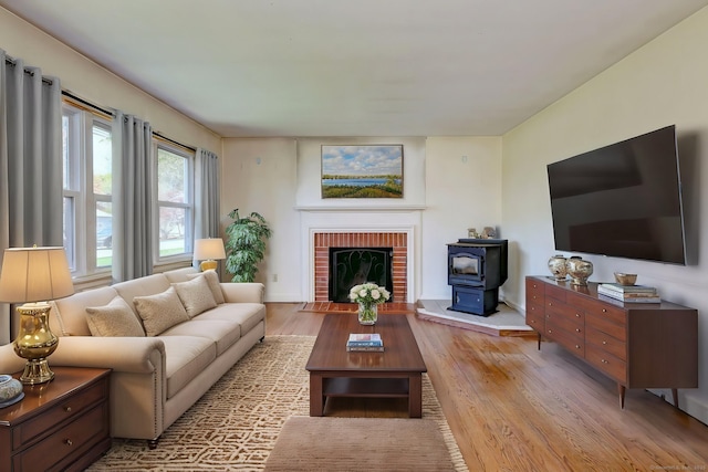 living area featuring a wood stove, wood finished floors, and baseboards