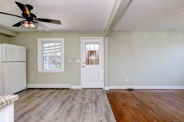 foyer entrance featuring a baseboard radiator, baseboards, ceiling fan, wood finished floors, and beamed ceiling