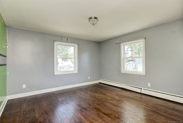 spare room featuring plenty of natural light, baseboards, wood finished floors, and baseboard heating