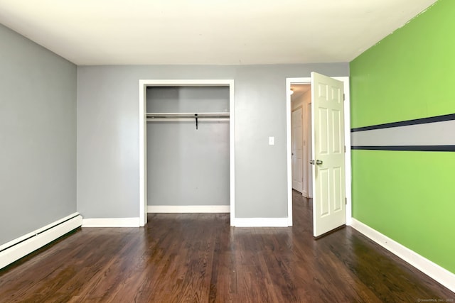 unfurnished bedroom featuring a baseboard radiator, a closet, baseboards, and wood finished floors
