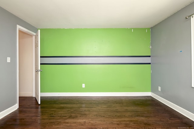 spare room with wood finished floors and baseboards