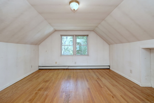 additional living space featuring baseboards, lofted ceiling, baseboard heating, and hardwood / wood-style flooring