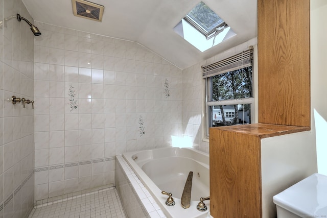full bath featuring a tub with jets, tile patterned flooring, lofted ceiling with skylight, and tiled shower