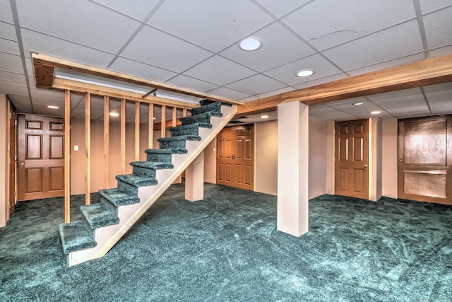 finished basement with stairway, dark carpet, and recessed lighting