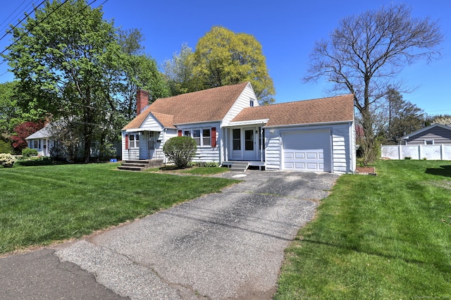 view of front facade featuring fence, driveway, a garage, a front lawn, and a chimney