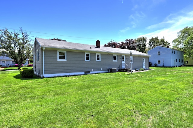 145 Russell Rd, Stratford, CT 06614 - back of property with entry steps, central AC, a chimney, and a lawn