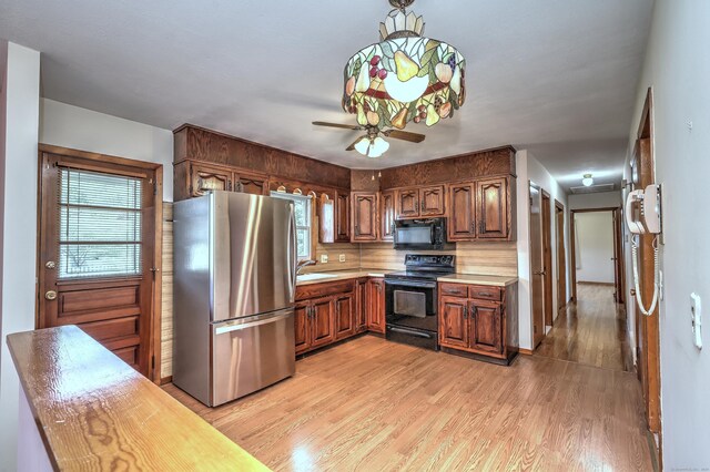 145 Russell Rd, Stratford, CT 06614 - kitchen with black appliances, light wood-style floors, light countertops, and plenty of natural light