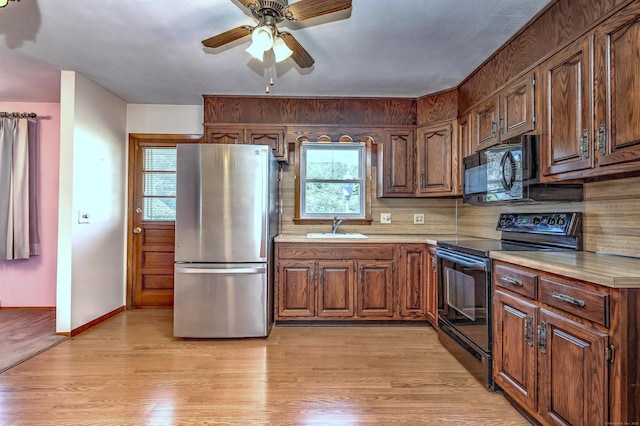 145 Russell Rd, Stratford, CT 06614 - kitchen with black appliances, light countertops, a sink, light wood-type flooring, and ceiling fan