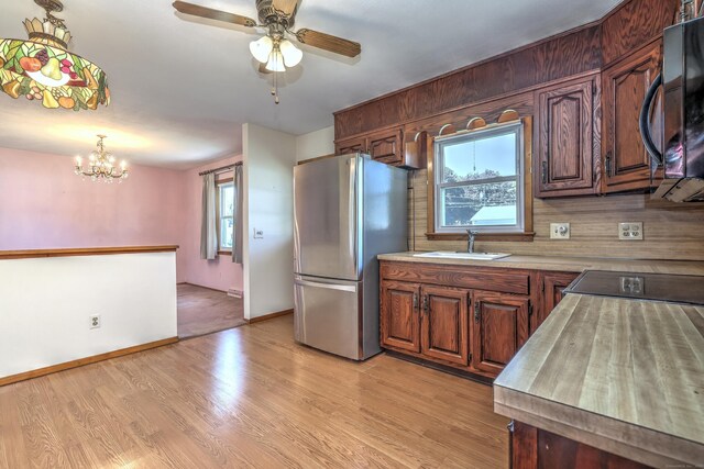 145 Russell Rd, Stratford, CT 06614 - kitchen featuring freestanding refrigerator, a sink, black microwave, and plenty of natural light