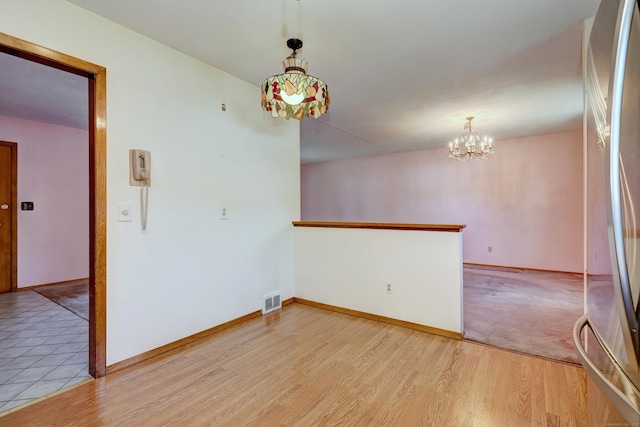 145 Russell Rd, Stratford, CT 06614 - unfurnished room with a chandelier, baseboards, and light wood-style floors