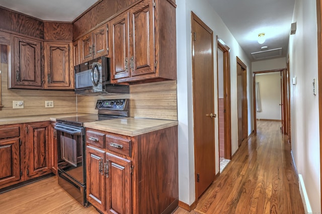 145 Russell Rd, Stratford, CT 06614 - kitchen featuring black appliances, light countertops, light wood-style flooring, backsplash, and baseboards