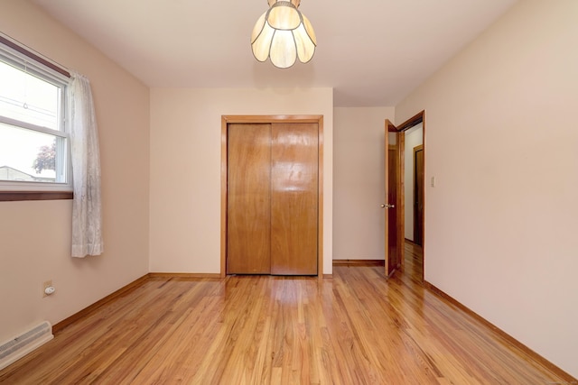 145 Russell Rd, Stratford, CT 06614 - unfurnished bedroom with a baseboard radiator, light wood-style flooring, baseboards, and a closet