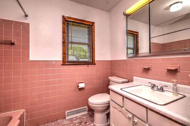 145 Russell Rd, Stratford, CT 06614 - full bath featuring tile patterned floors, toilet, tile walls, a wainscoted wall, and vanity