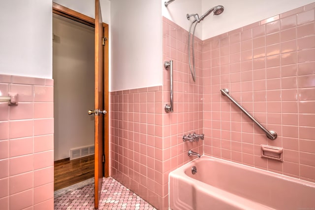 145 Russell Rd, Stratford, CT 06614 - bathroom featuring tile walls, tile patterned flooring, wainscoting, and shower / washtub combination