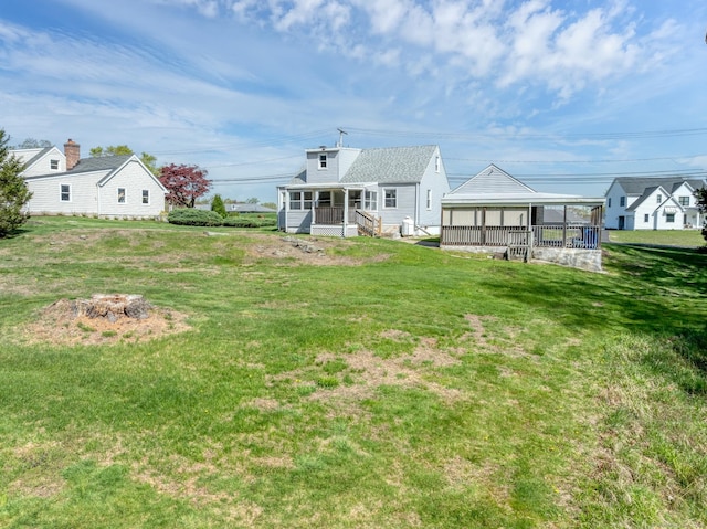 rear view of property with a yard, a sunroom, and a fire pit