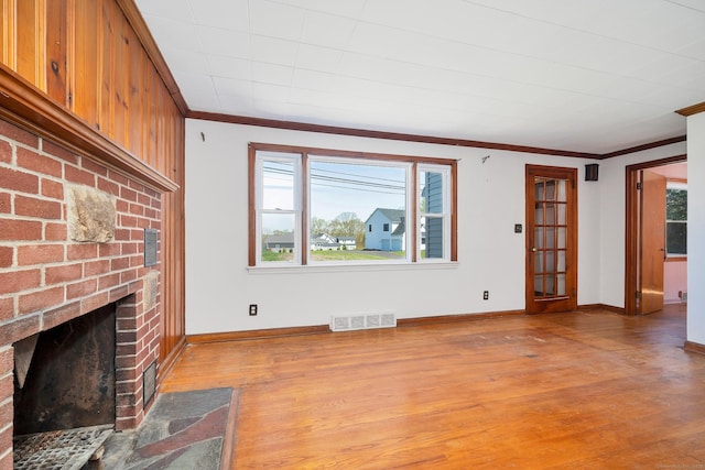 unfurnished living room featuring visible vents, crown molding, a wealth of natural light, and a fireplace