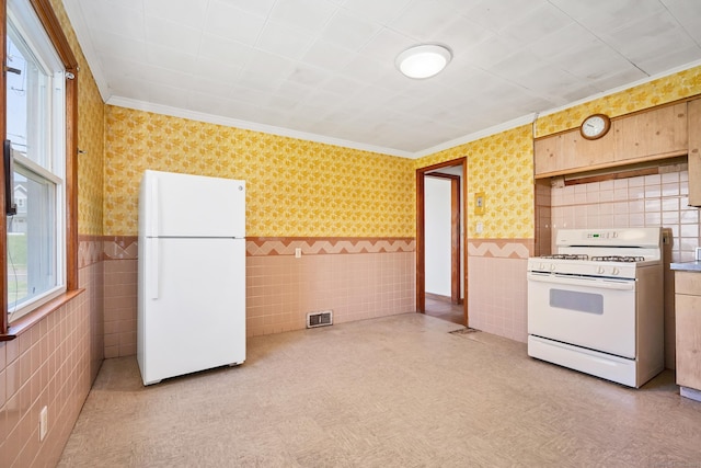 kitchen featuring white appliances, crown molding, tile walls, and visible vents