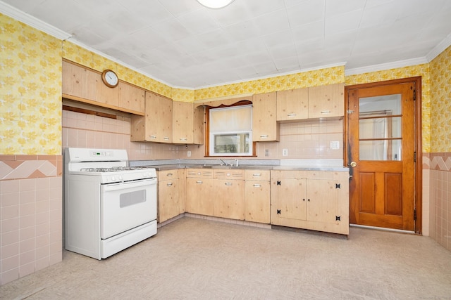 kitchen featuring light brown cabinetry, tile walls, light floors, wallpapered walls, and white range with gas cooktop