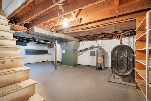 unfinished basement featuring water heater, heating unit, and heating fuel