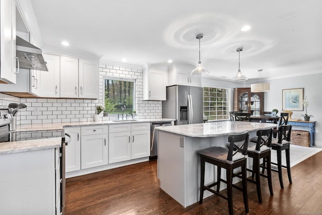 kitchen featuring a sink, light stone countertops, stainless steel appliances, and extractor fan