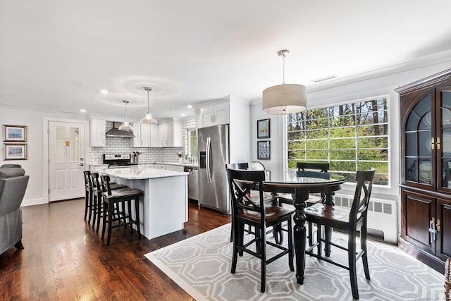 dining space featuring dark wood-style flooring, visible vents, a healthy amount of sunlight, and radiator heating unit