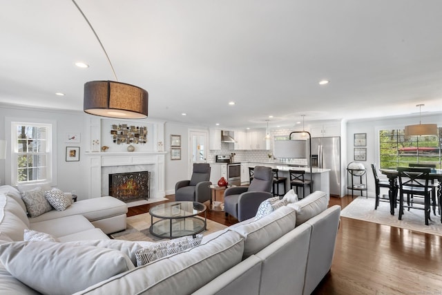 living room featuring a healthy amount of sunlight, recessed lighting, and dark wood-type flooring